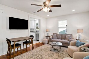 A modern living room with a dining table, sofa, and a ceiling fan. - Callahan`s Hideaway on Marine (Mobile)