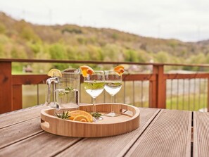 A wooden table with a tray holding a pitcher and two glasses, set against a scenic outdoor backdrop. - Holiday Apartment Mila OG (Rieden)