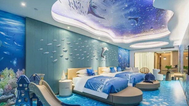 Quarto com cama, mesa de cabeceira, cômoda, painel decorativo na parede, painel decorativo no teto e área da piscina.