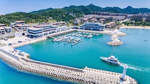 Un puerto deportivo con barcos amarrados, un faro y edificios al fondo.
