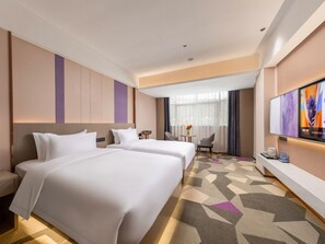 A hotel room with two beds, a desk, a chair, a TV, and a window with curtains. - Lavande Hotel (Zhuhai)