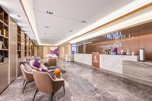 A modern reception area with a marble floor, seating, and a reception desk. - Lavande Hotel (Zhuhai)