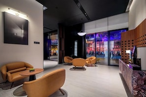 A modern lobby with leather seating, a reception desk, and a view of a busy street outside. - Intercityhotel Guangzhou Panyu Chimelong Wanbo Sihai City (Guangzhou)