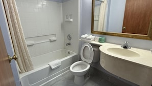 Ein Badezimmer mit Badewanne, Toilette, Waschbecken und Spiegel.