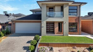 A two-story house with a garage, a balcony, and a well-maintained lawn. - Spacious 8-Bedroom Berwick Retreat – Perfect for Groups & Families (Berwick)