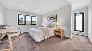 A bedroom with a bed, bedside tables, a desk, and chairs. - Spacious 8-Bedroom Berwick Retreat – Perfect for Groups & Families (Berwick)