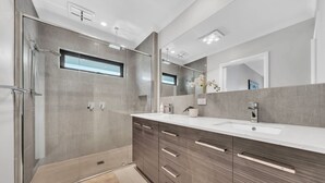 A modern bathroom with a walk-in shower, a large mirror, and a vanity with a sink. - Spacious 8-Bedroom Berwick Retreat – Perfect for Groups & Families (Berwick)