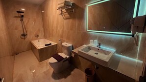 Ein modernes Badezimmer mit Badewanne, Toilette und Waschbecken.