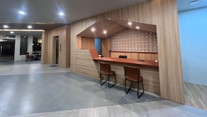Ein modernes Interieur mit einer Rezeption, einer Sitzecke und einer Wand mit Muster.