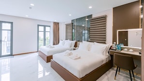 A hotel room with two beds, a desk, and a bathroom. - VIN Hotel (Phuoc Hau)