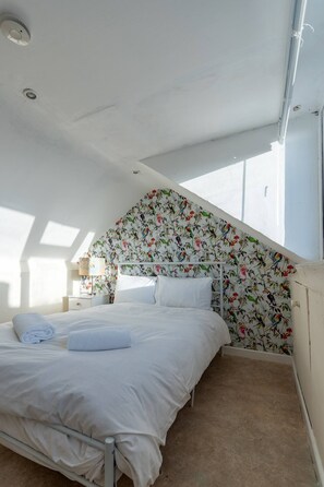A bedroom with a bed, a nightstand, and a window. - 3BR home in Southend | Sleeps 8 - Pass the Keys (Southend-on-Sea)