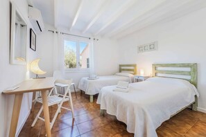 A bedroom with two beds, a desk, and a chair. - Vrbo Property (Pollenca)