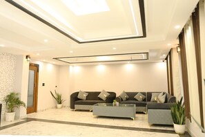 A modern living room with a sofa set, a coffee table, and potted plants. - Hotel Citizen- Near Yashobhoomi (New Delhi)