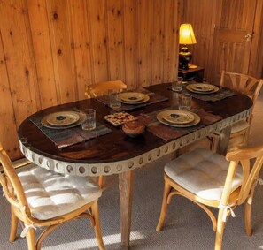 A wooden dining table with four chairs, a lamp, and a placemat. - Treehouse like escape in North Asheville (Woodfin)
