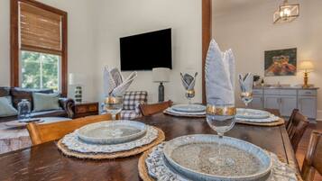 A dining table set with plates, glasses, and napkins.