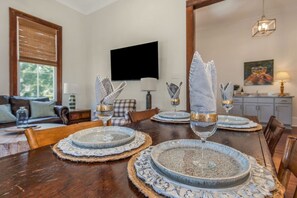 A dining table set with plates, glasses, and napkins. - Elmira in Oakleigh Garden (Mobile)