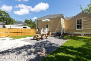 A residential property with a covered patio, a wooden fence, and a gravel driveway. - Elmira in Oakleigh Garden (Mobile)