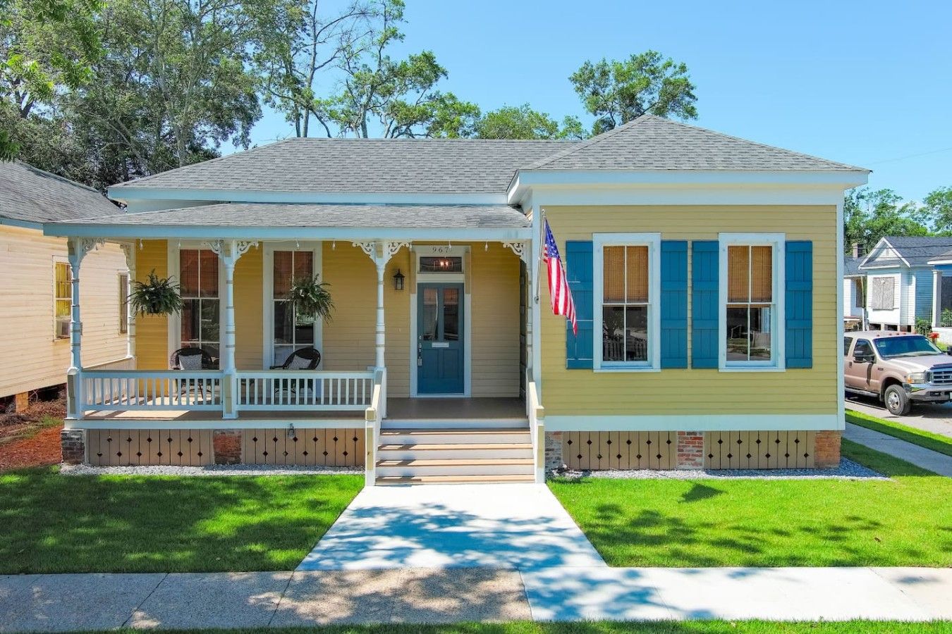 A two-story house with a porch, a front door, and a small front yard.