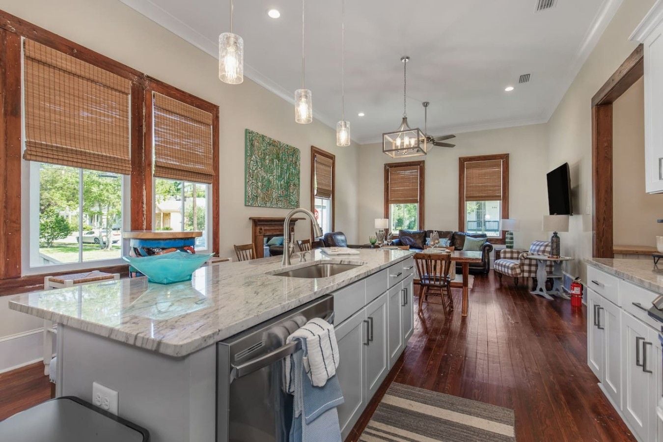 A spacious kitchen with a large island, wooden flooring, and a dining area with a view.