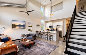 A spacious living area with a sofa, coffee table, and artwork on the wall. - ✨ Modern 2BR Lyndon Loft Oasis | Work & Play| Private Patio | 2-Car Garage (Louisville)