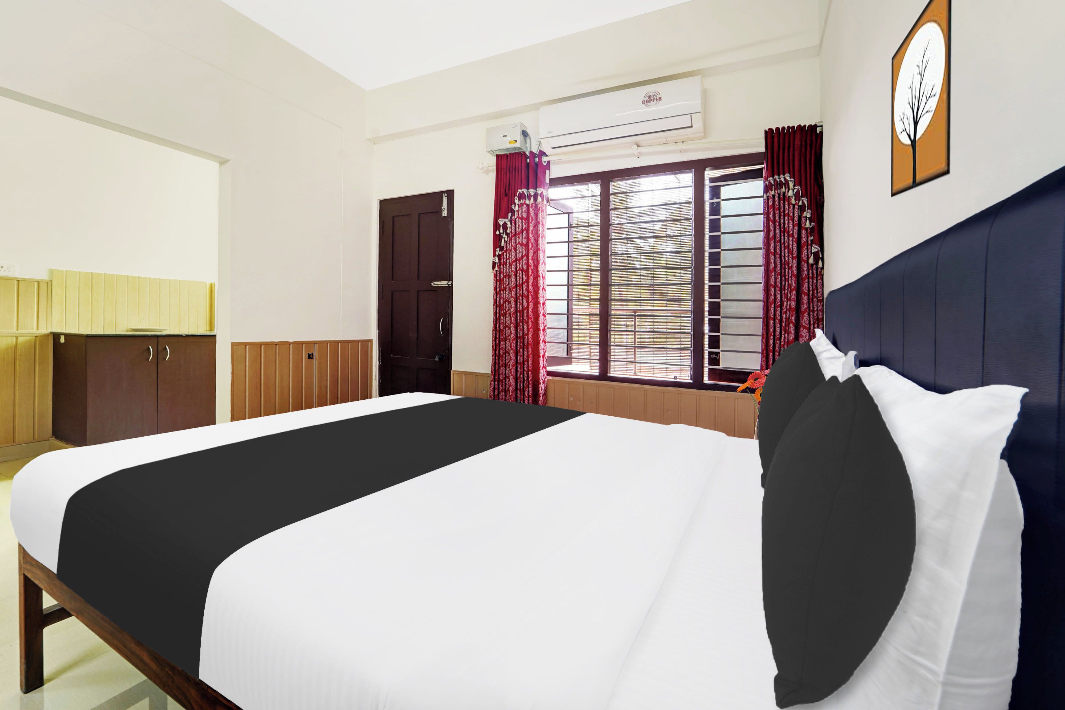 Habitación de hotel con cama, armario, ventana con cortinas, equipo de aire acondicionado y un reloj de pared.