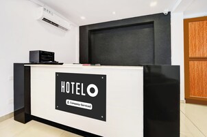 Mostrador de recepción de hotel con un letrero que indica servicio de empresa.