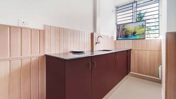 Una cocina con armarios de madera, una encimera y una ventana con vistas al verdor.