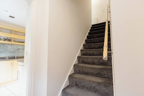 A staircase with carpeted steps leading to a landing. - Uncle Bill`s Cottage (Thongsbridge)
