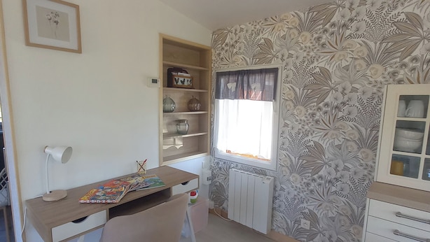 A room with a desk, chair, radiator, and a window with curtains. - A Little Paradise (Sanghen)