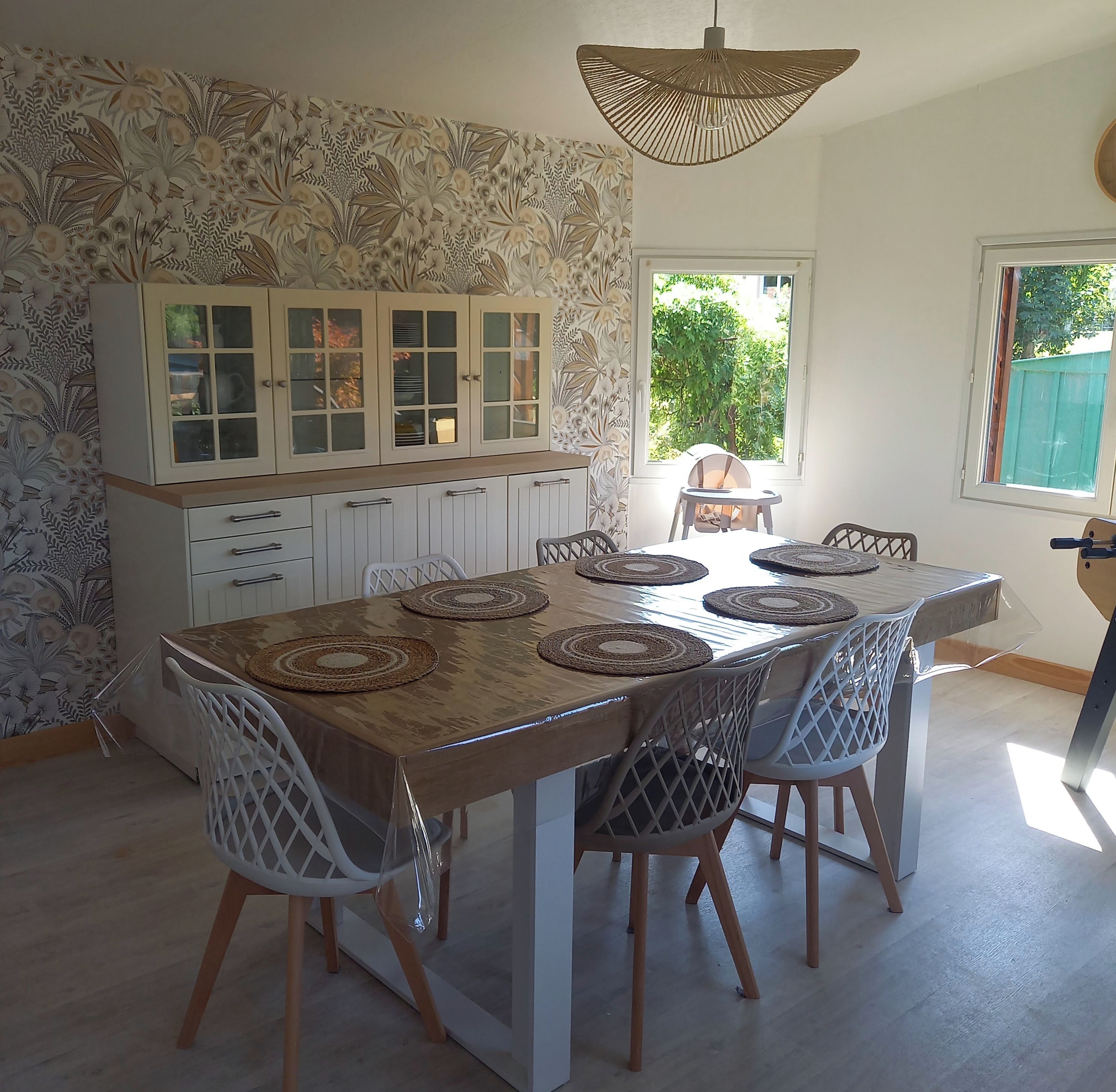 A dining area with a table, chairs, and a cabinet with glass doors.