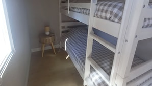 A bunk bed room with a small table and a lamp. - A Little Paradise (Sanghen)