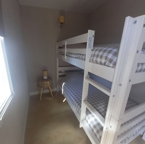 A bunk bed room with a small table and a lamp. - A Little Paradise (Sanghen)