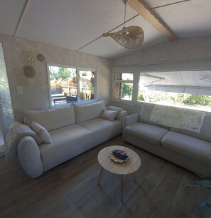 A living room with two sofas, a coffee table, and a ceiling fan.