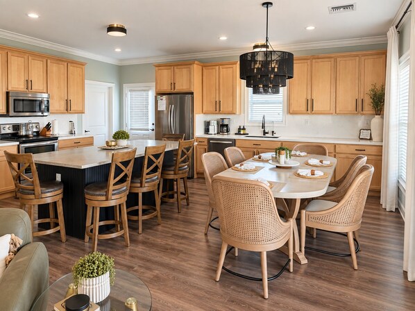Una cocina moderna con armarios de madera, electrodomésticos de acero inoxidable y una isla central con asientos.