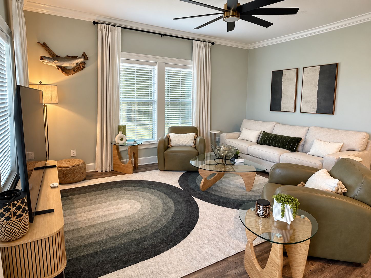 A modern living room with a sofa, armchairs, a coffee table, and a TV.