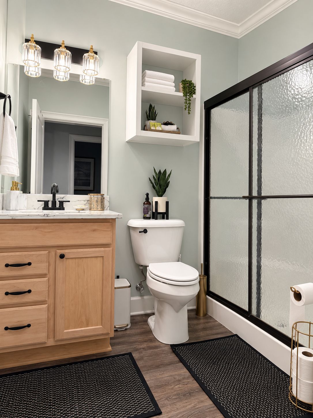 A modern bathroom with a white vanity, a toilet, and a shower area.