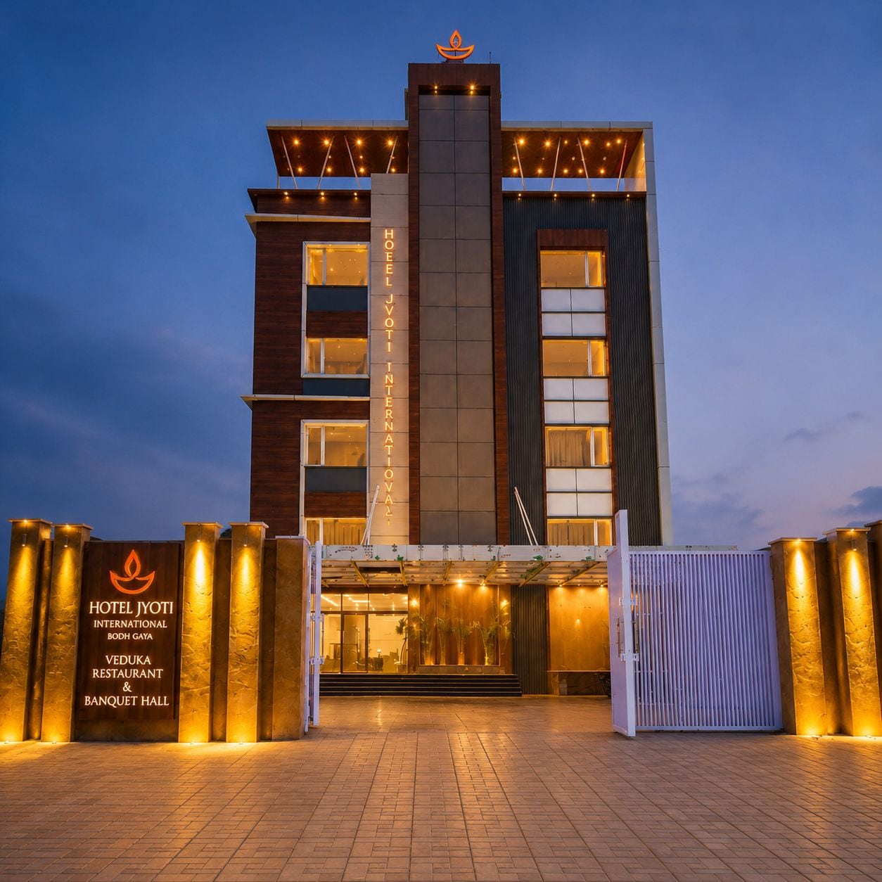 Un hôtel moderne, avec une entrée imposante, une enseigne lumineuse et une façade bien éclairée.