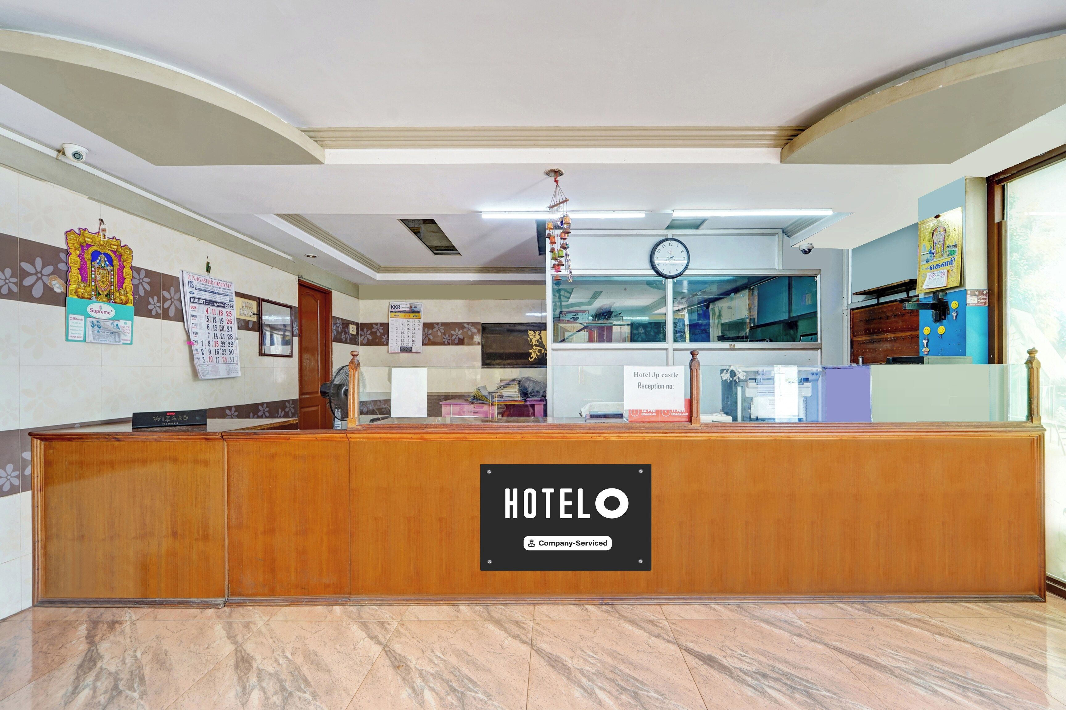 Una recepción de hotel con un letrero que dice 'HOTELO', un reloj y un calendario en la pared.