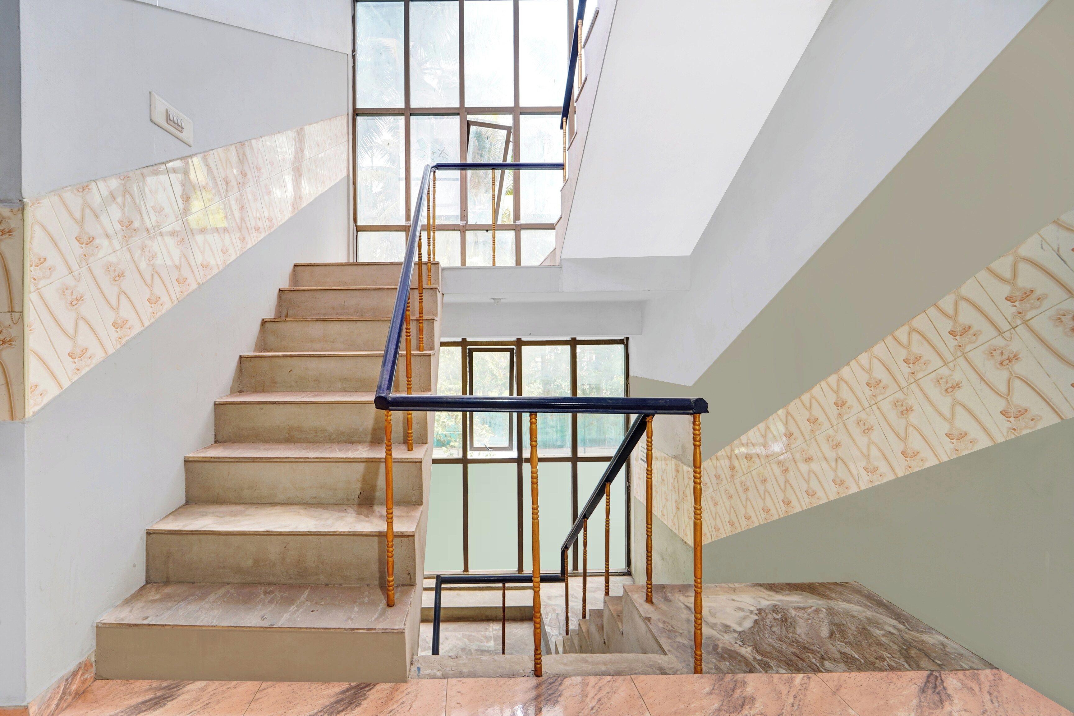 A staircase with a glass railing, leading to a higher floor.