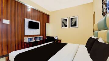 Ein Hotelzimmer mit einem Bett, einem Fernseher, einem Schreibtisch und zwei gerahmten Bildern an der Wand.