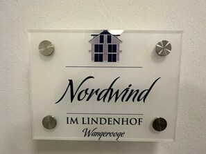 Une enseigne portant les inscriptions « Nordwind » et « Im Lindenhof », indiquant un hôtel ou un établissement proposant des hébergements.