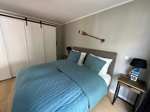 Une chambre à coucher comprenant un lit, une table de chevet, une pagaie fixée au mur et une armoire.