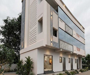 A modern two-story building with a flat roof, large windows, and a balcony. - Deluxe Room Sba's Park Inn (Coimbatore)