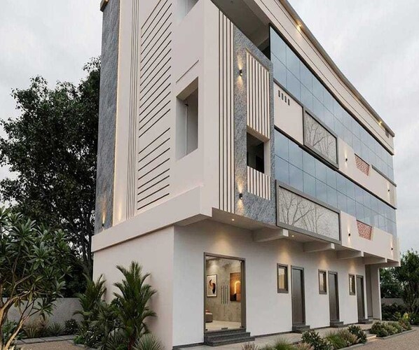 A modern two-story building with a flat roof, large windows, and a balcony.