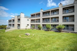 A multi-story residential building with a well-maintained lawn and a circular stone feature. - Newly Renovated Beech Mountain Bliss; Be close to all the action (Beech Mountain)