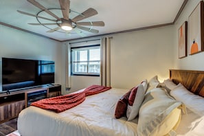 A hotel room with a bed, a television, a ceiling fan, and a window with blinds. - Newly Renovated Beech Mountain Bliss; Be close to all the action (Beech Mountain)