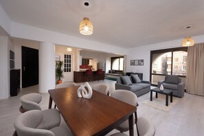 A modern living room with a dining area, a kitchen in the background, and large windows. - perfect stay at Mexican by Spacey #12 (cairo)