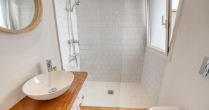 A bathroom with a white sink, a shower, and a window. - Rustic-modern style apartment with sea views (Calella de Palafrugell)