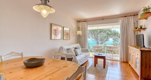 Un salon chaleureux avec une table à manger, un canapé et un balcon offrant une belle vue.