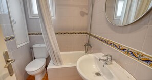 Ein Badezimmer mit Toilette, einer Badewanne und einem Waschbecken.